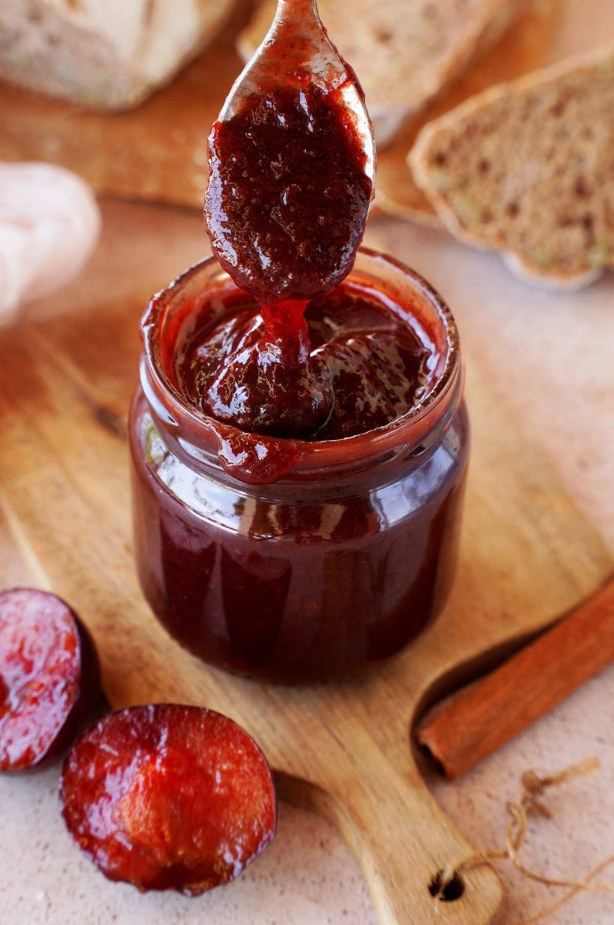 close-up plum jam in jar with spoon