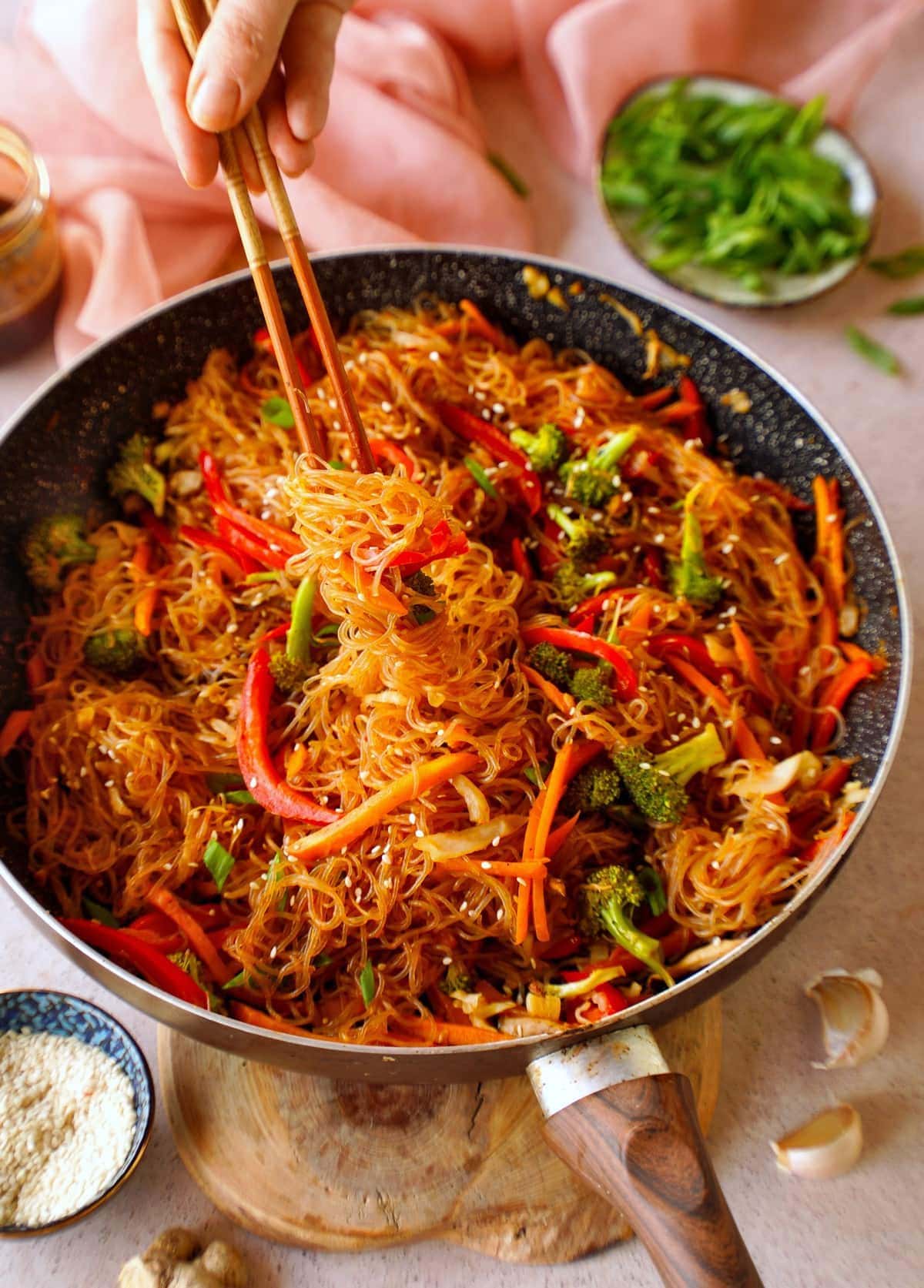 eating Asian vermicelli stir-fry noodles with chopsticks from skillet