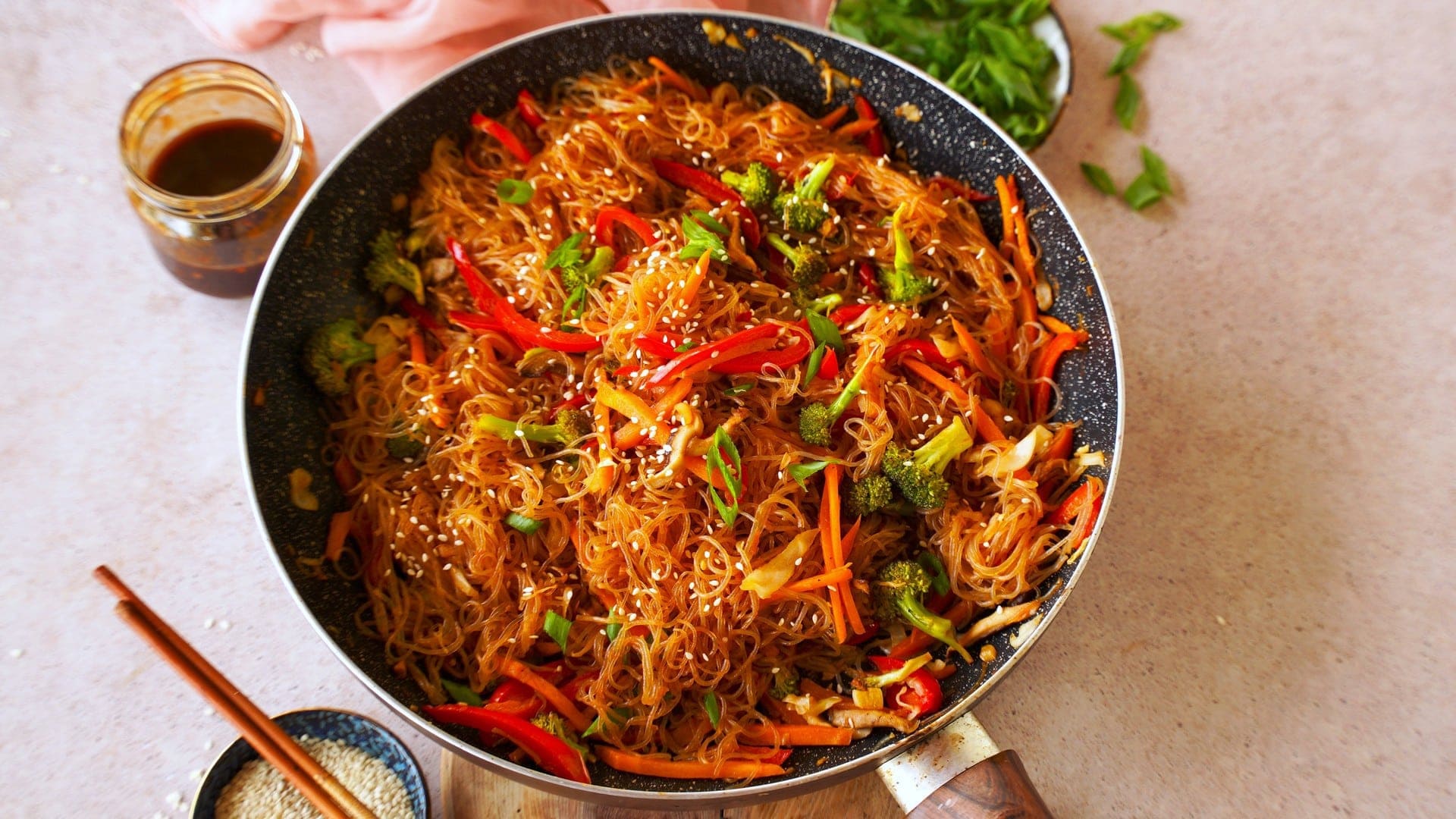 Queraufnahme von asiatischen Stir-Fry Nudeln mit Gemüse in schwarzer Pfanne