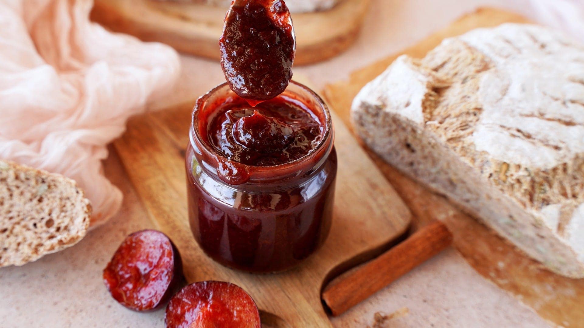 horizontal shot plum jam in jar with spoon