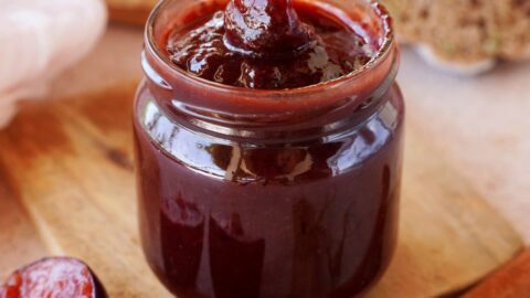 plum jam in jar with spoon