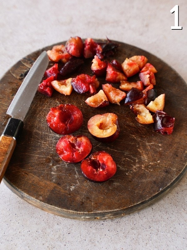 slicing plums on wooden board