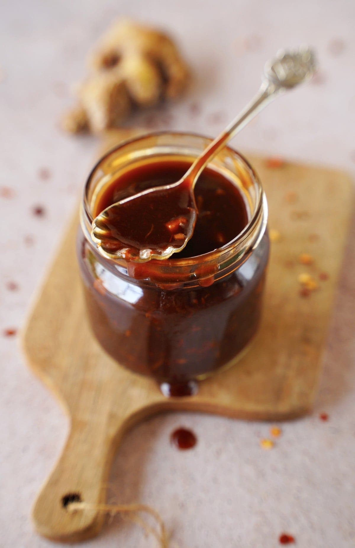 top shot of Korean barbecue sauce in jar with spoon on wooden board