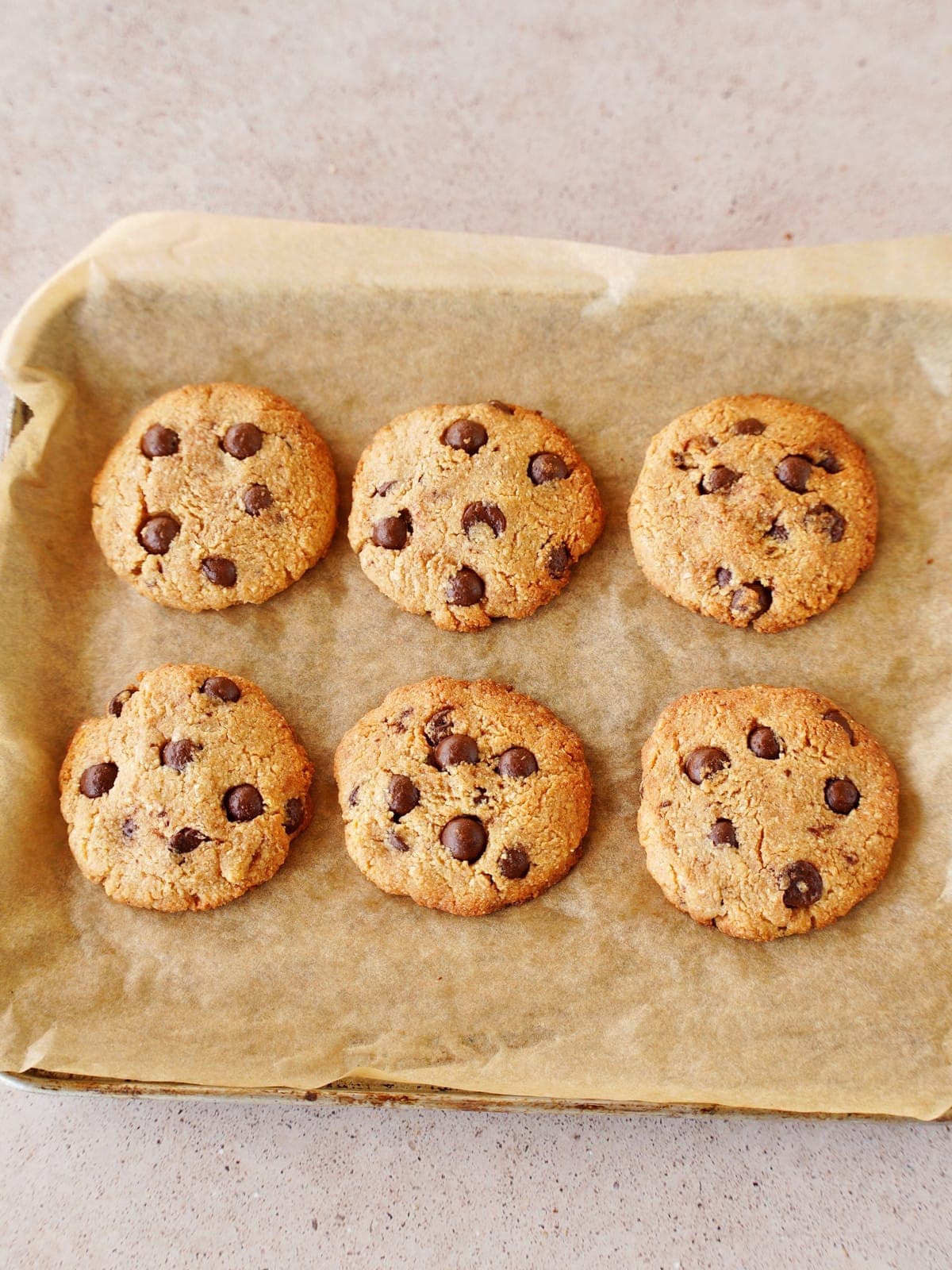 6 gesunde Chocolate Chip Cookies aus Mandeln nach dem Backen auf einem Backblech