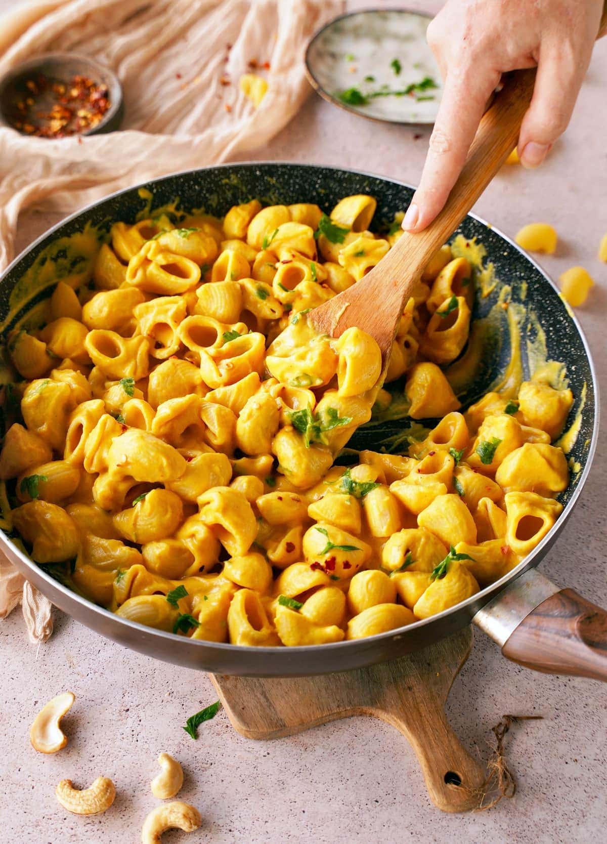 dairy-free butternut mac and cheese in black skillet with wooden spoon