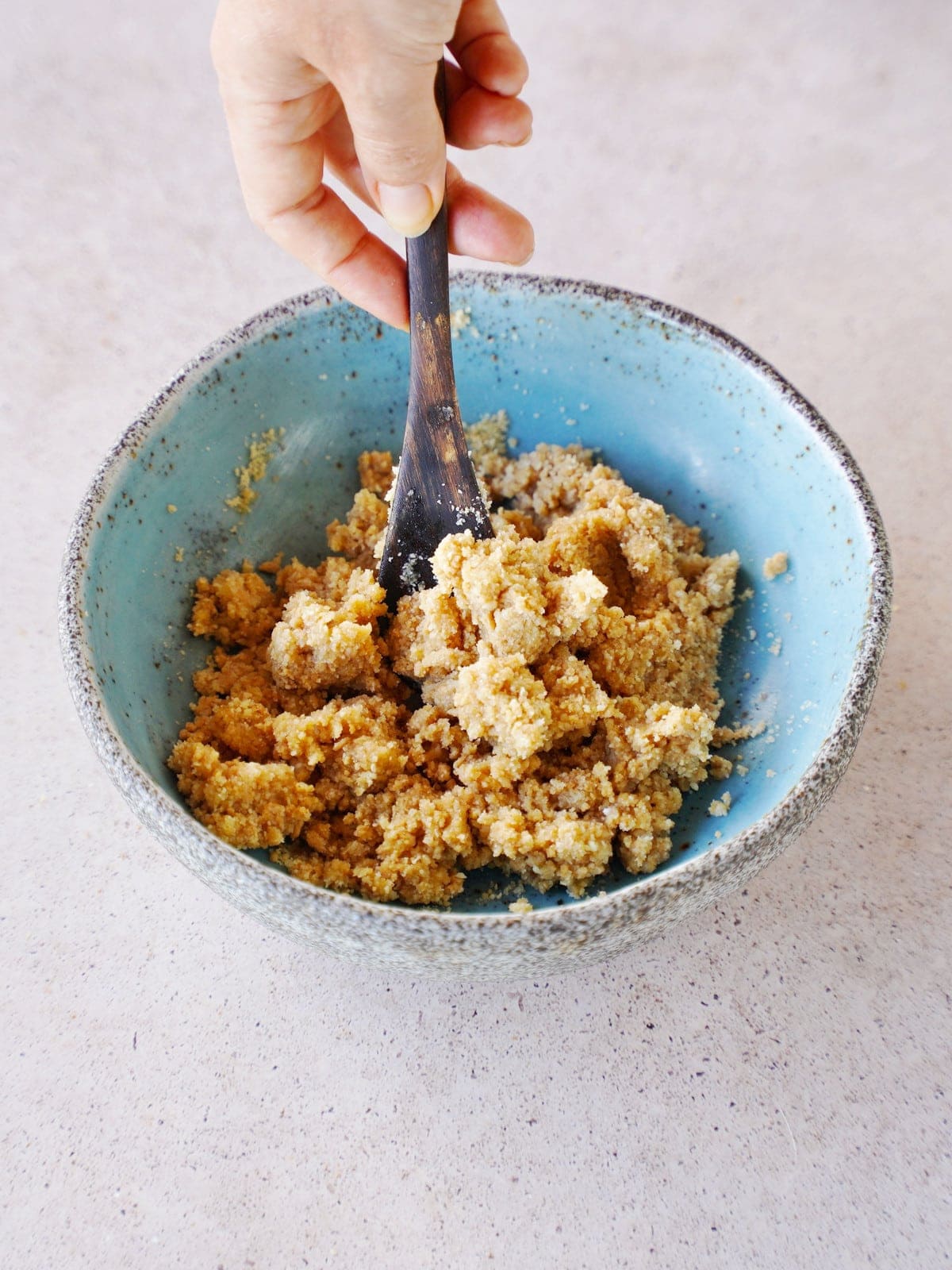 mixing cookie dough in blue bowl with spoon