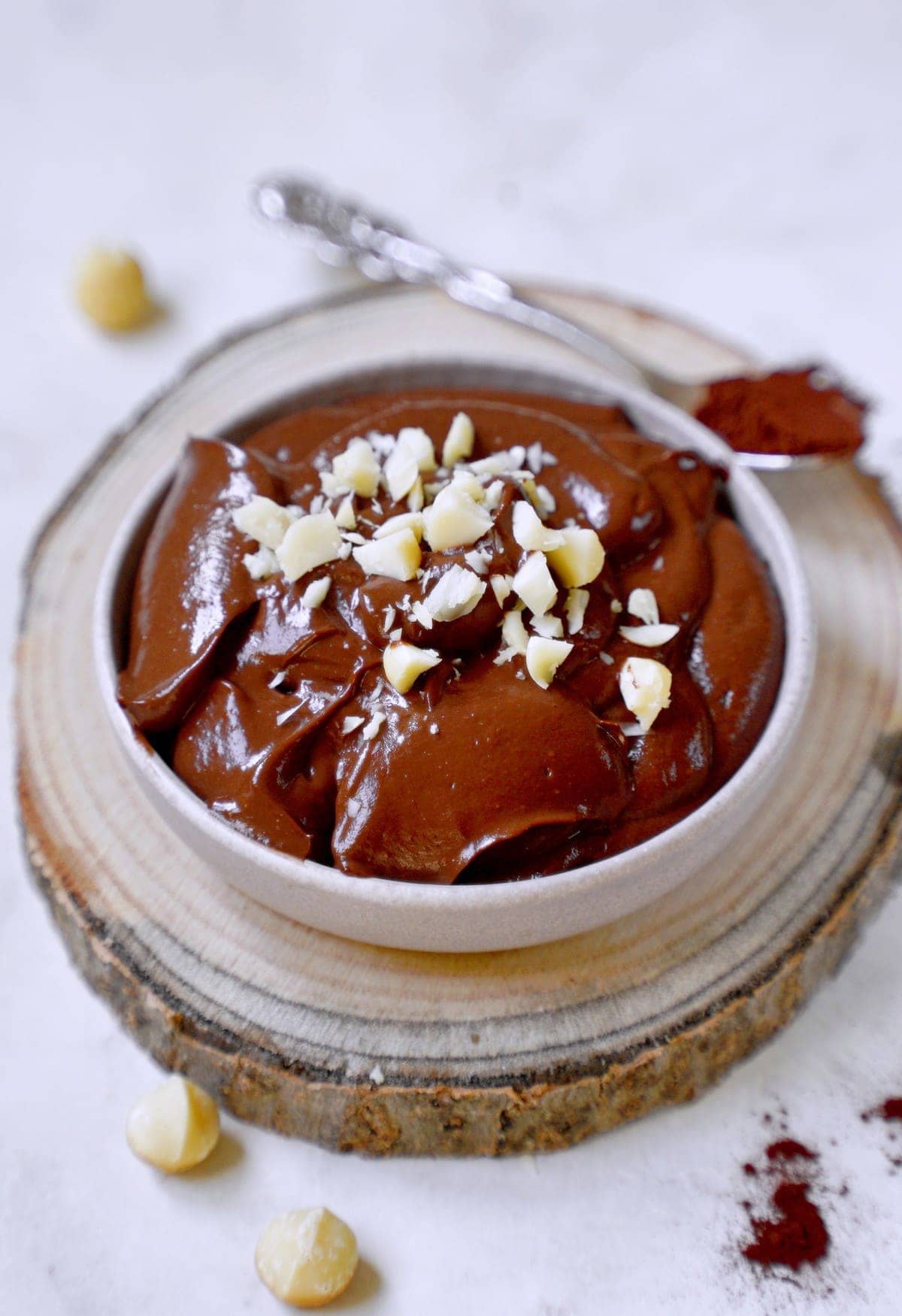 avo chocolate pudding in bowl with crushed nuts