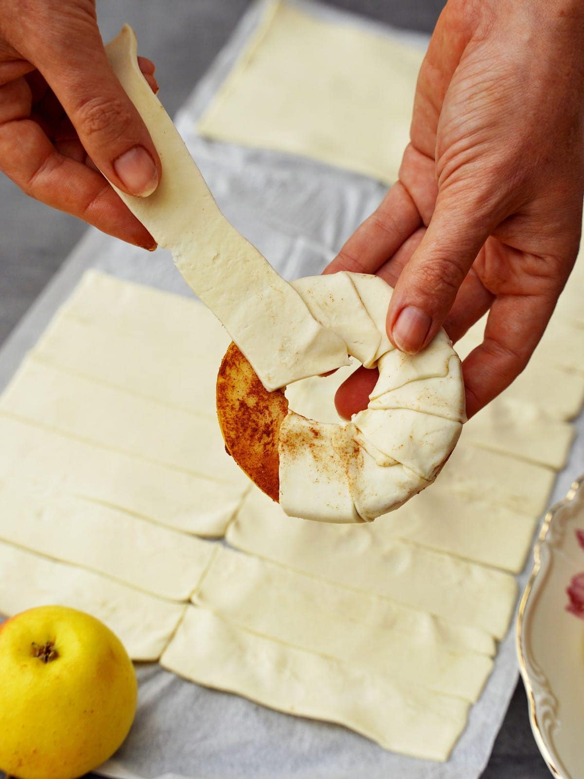 wrapping puff pastry strips around apple rings