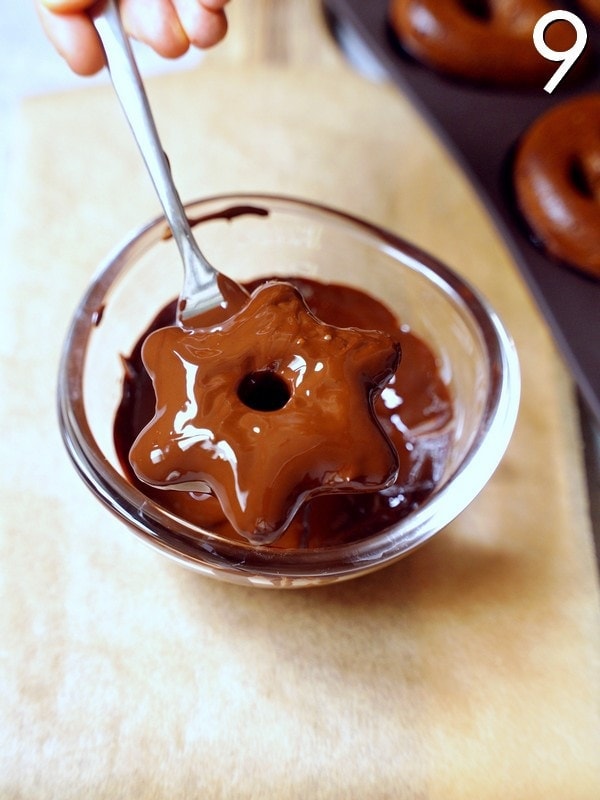 Lebkuchenstern wird in eine Schale mit geschmolzener Schokolade eingetaucht