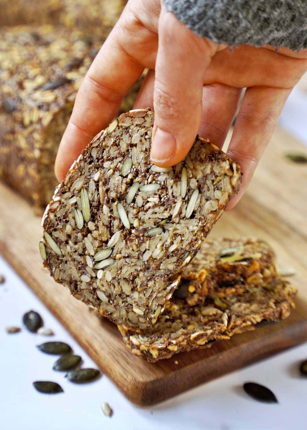 hand showing a slice of seed bread
