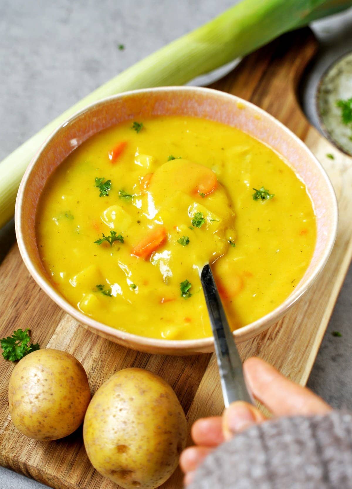 vegane Kartoffel-Lauch-Suppe in Schüssel mit Löffel