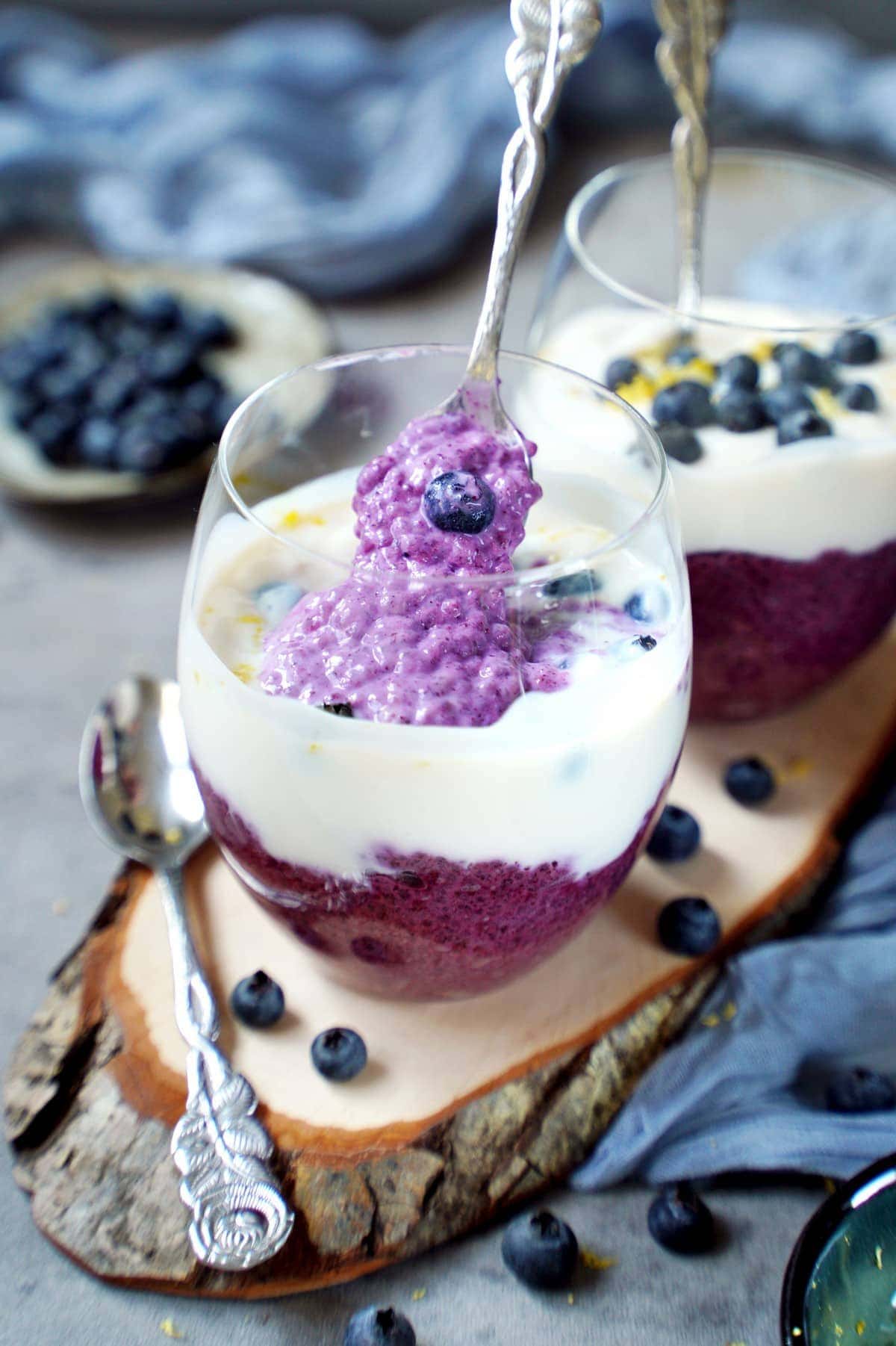Blaubeer-Chia-Pudding in zwei Gläsern mit Joghurt und frischen Blaubeeren