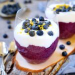 blueberry chia seed pudding in two jars with yogurt and fresh berries