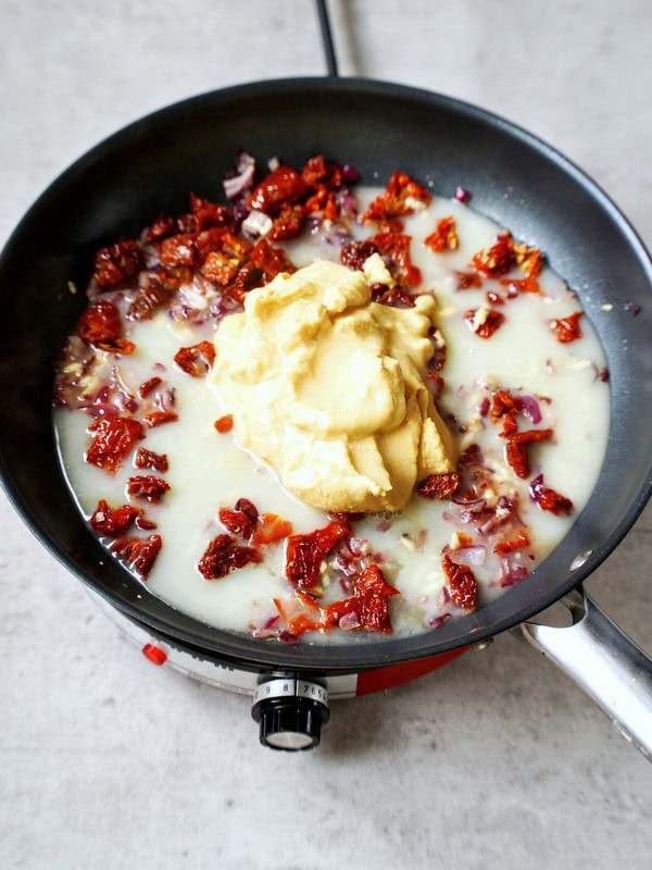 hummus and sun-dried tomatoes in skillet