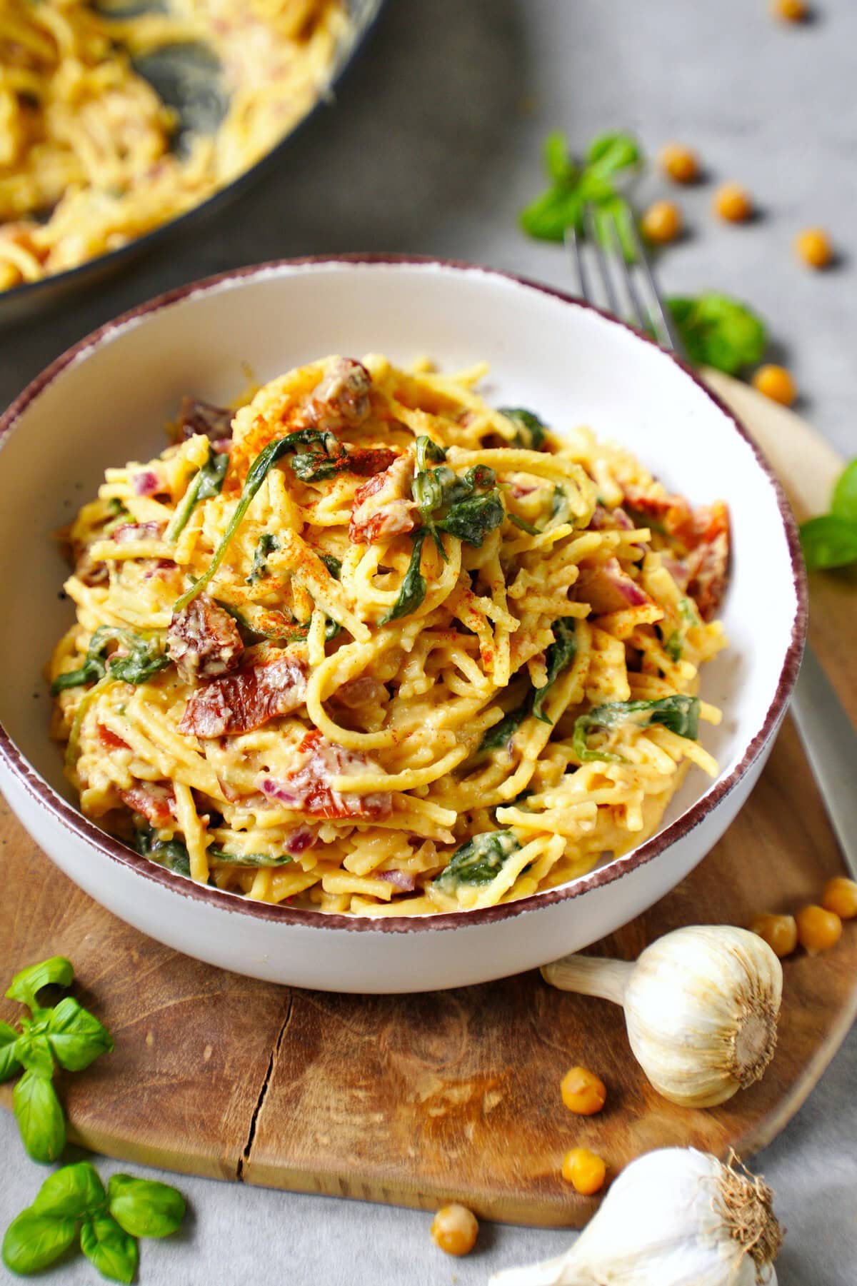 hummus pasta with sun-dried tomatoes and spinach in bowl
