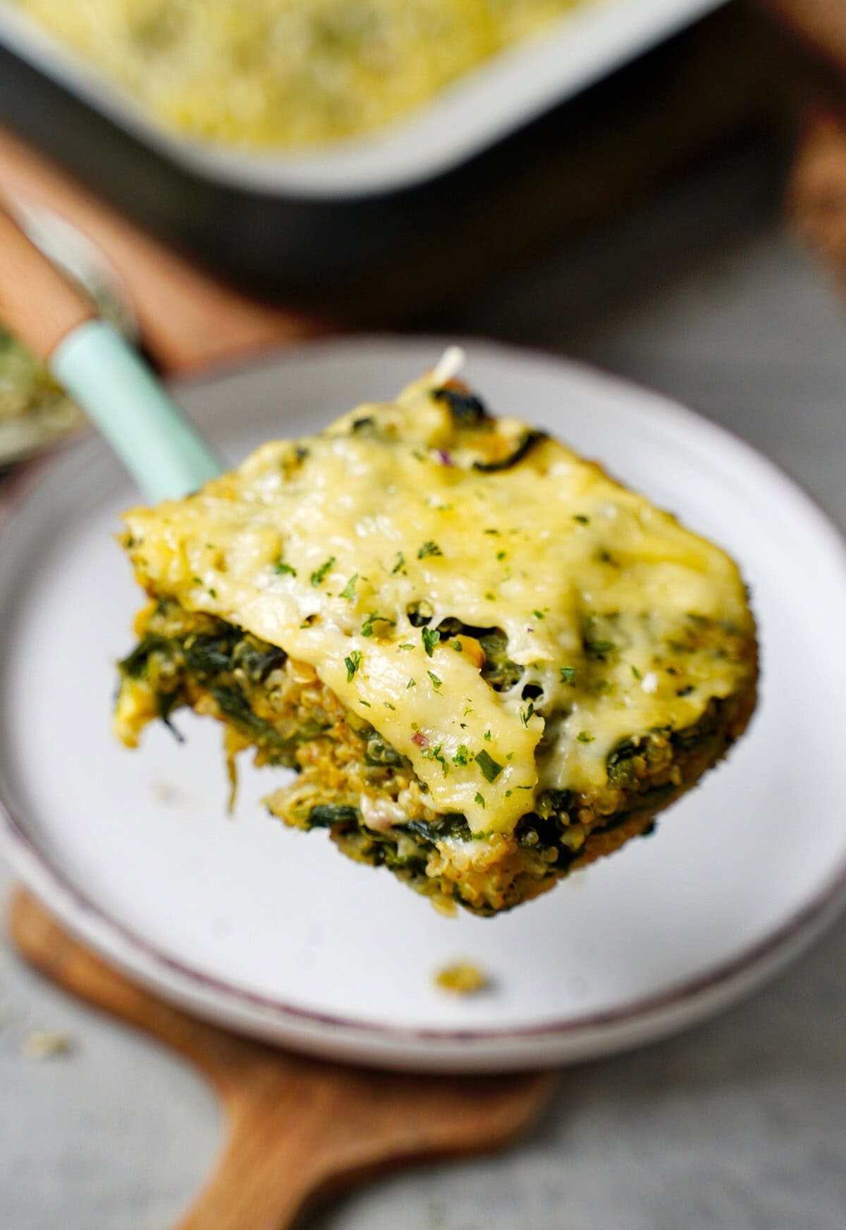 piece of spinach casserole with quinoa, lentils, and cheese