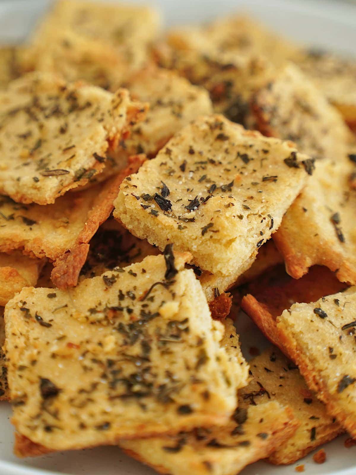 close-up of golden-brown, herb-topped chickpea crackers