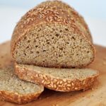 A freshly baked, round loaf of chickpea bread with flaxseeds