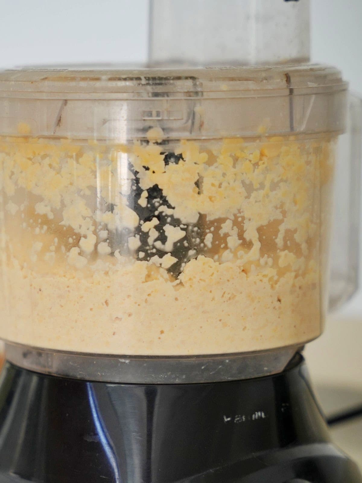 Close-up of a food processor blending a creamy chickpea mixture