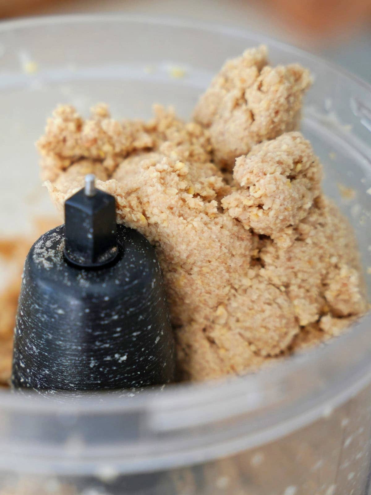 Close-up of crumbly dough being mixed in a food processor