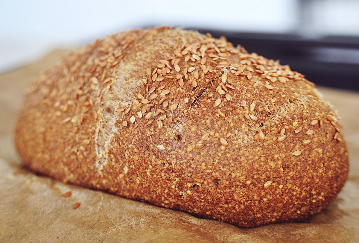 Loaf of freshly baked chickpea bread on parchment paper