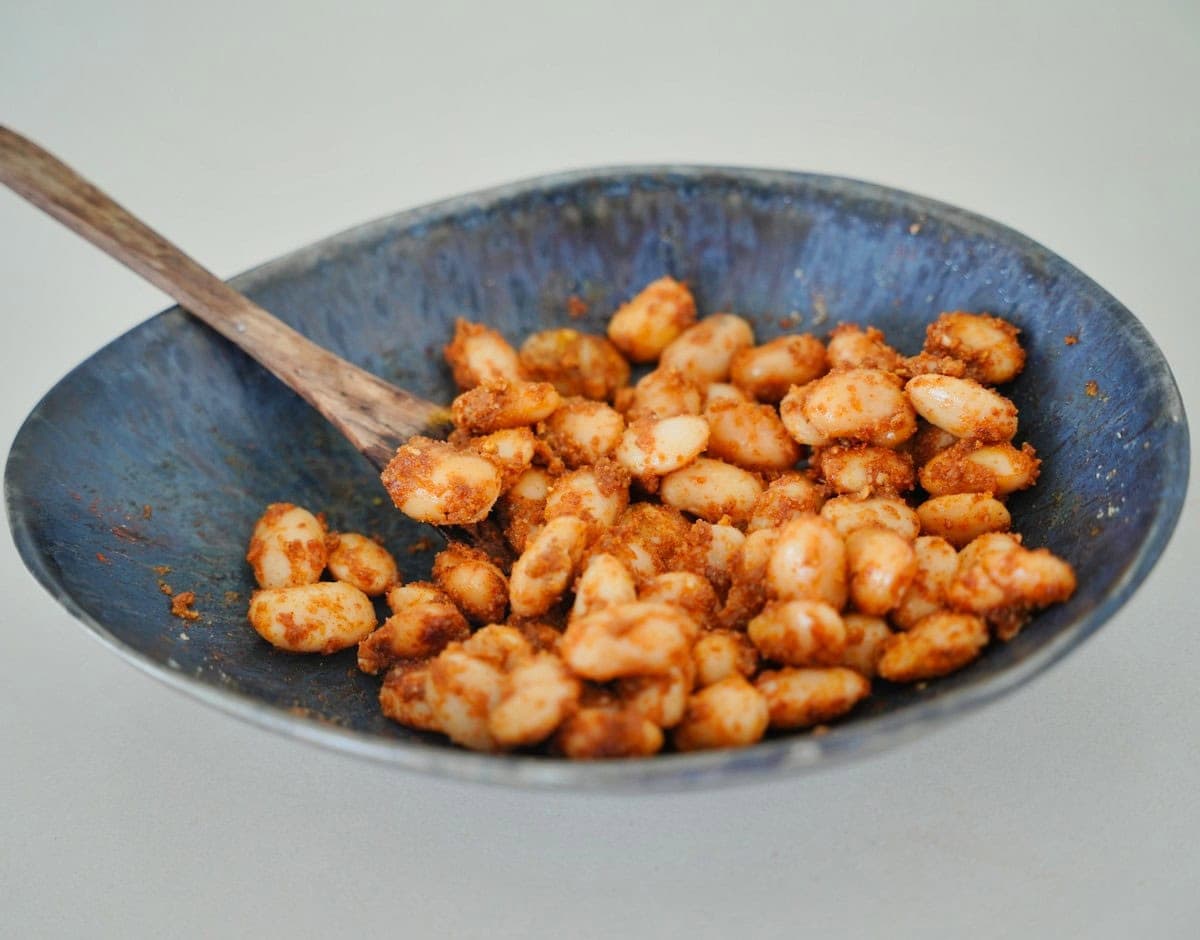 Riesenbohnen in einem Keramikteller mit Gewürzen vermischt