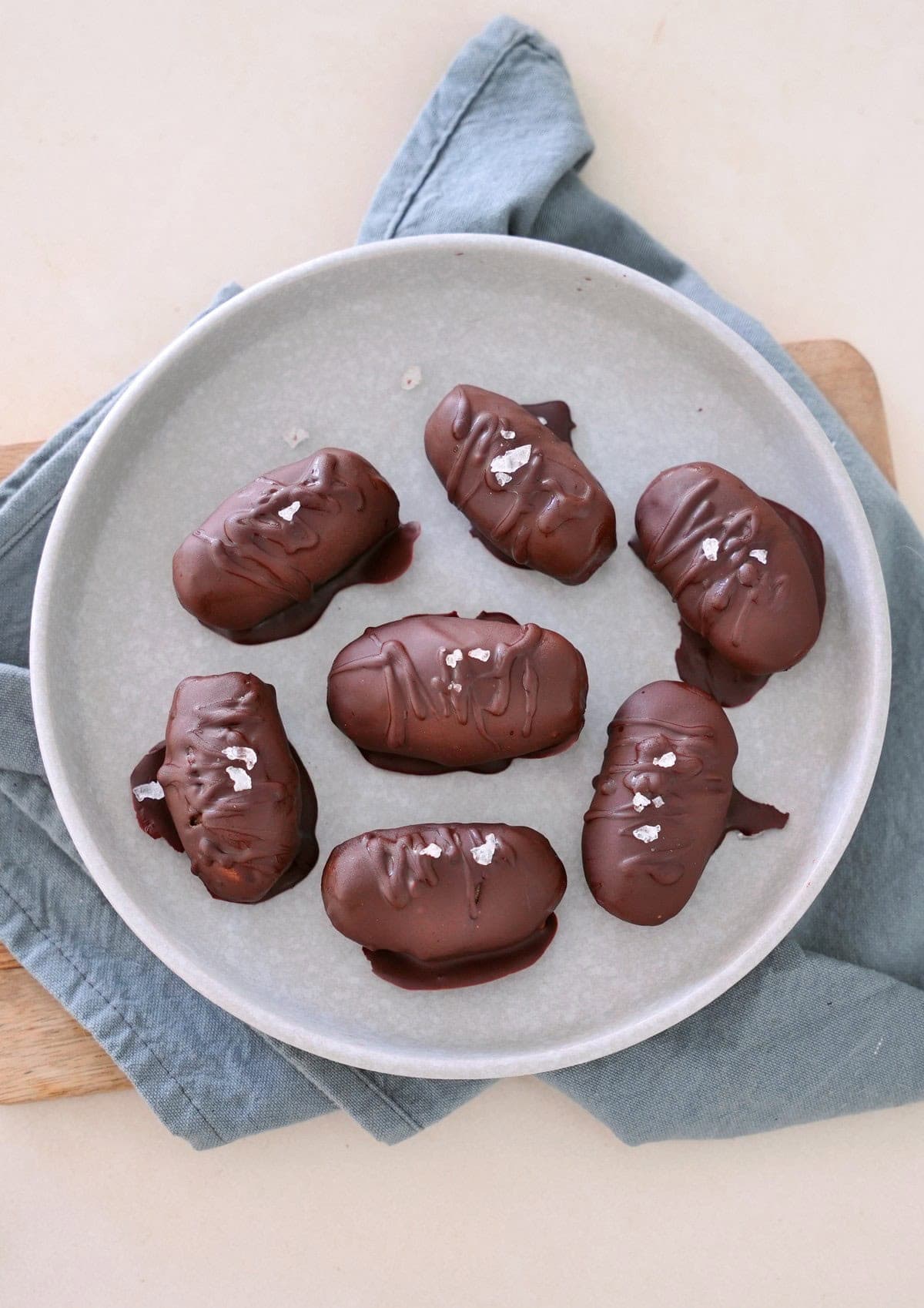 Schokoladenüberzogene Kichererbsen Pralinen, mit Salz bestreut, angerichtet auf einem gesprenkelten grauen Teller 