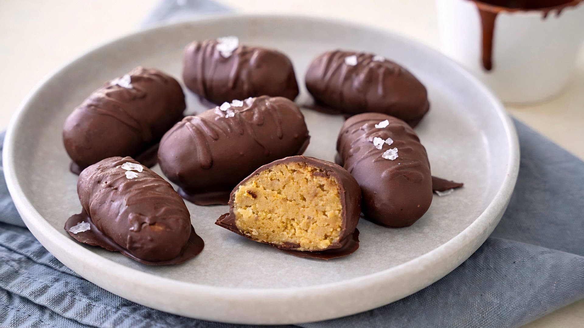 Hausgemachte Kichererbsen Schokoladenpralinen mit Meersalz garniert auf grauem Teller 