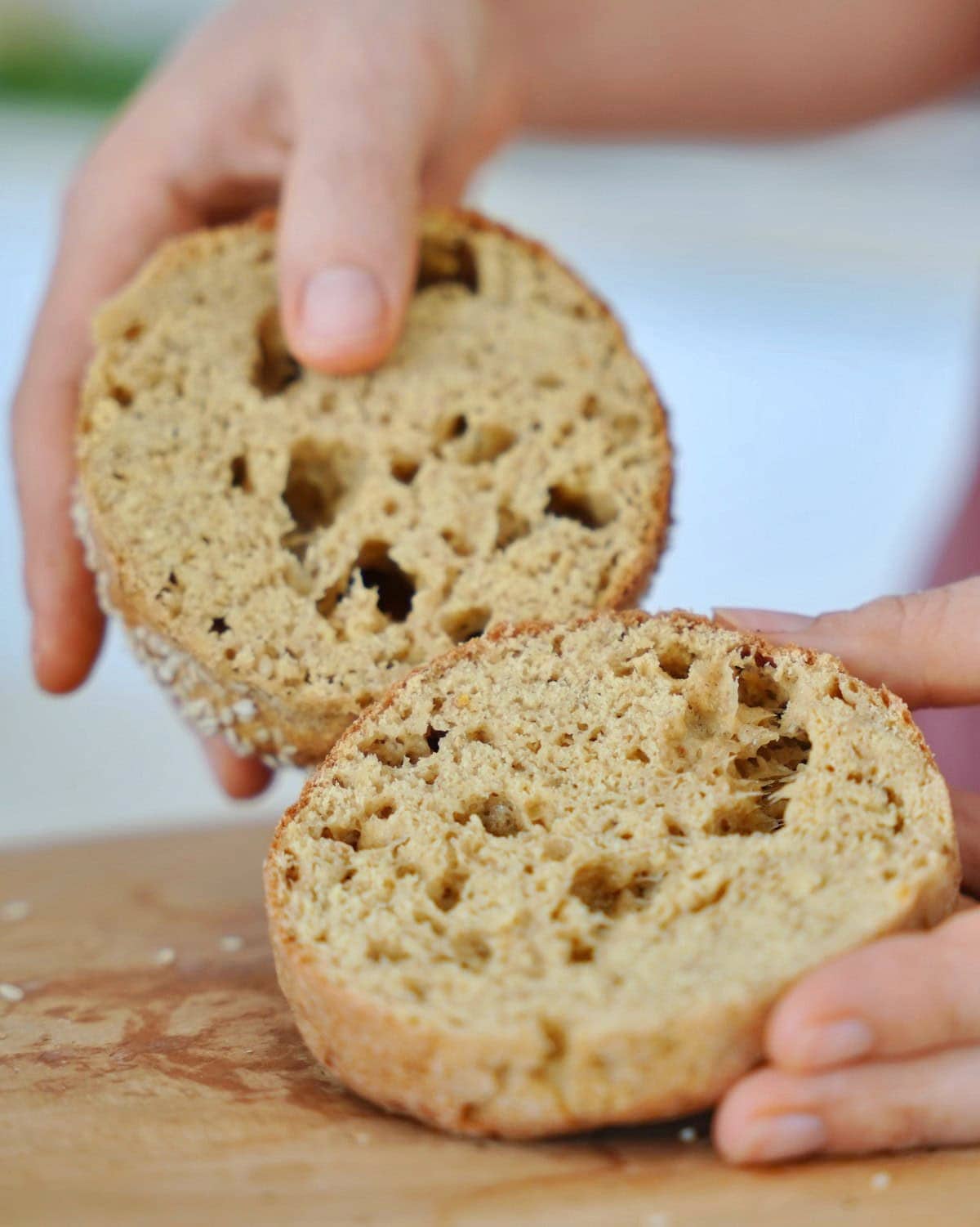 Halved burger bun. The bread has an airy texture with visible holes and a lightly browned crust