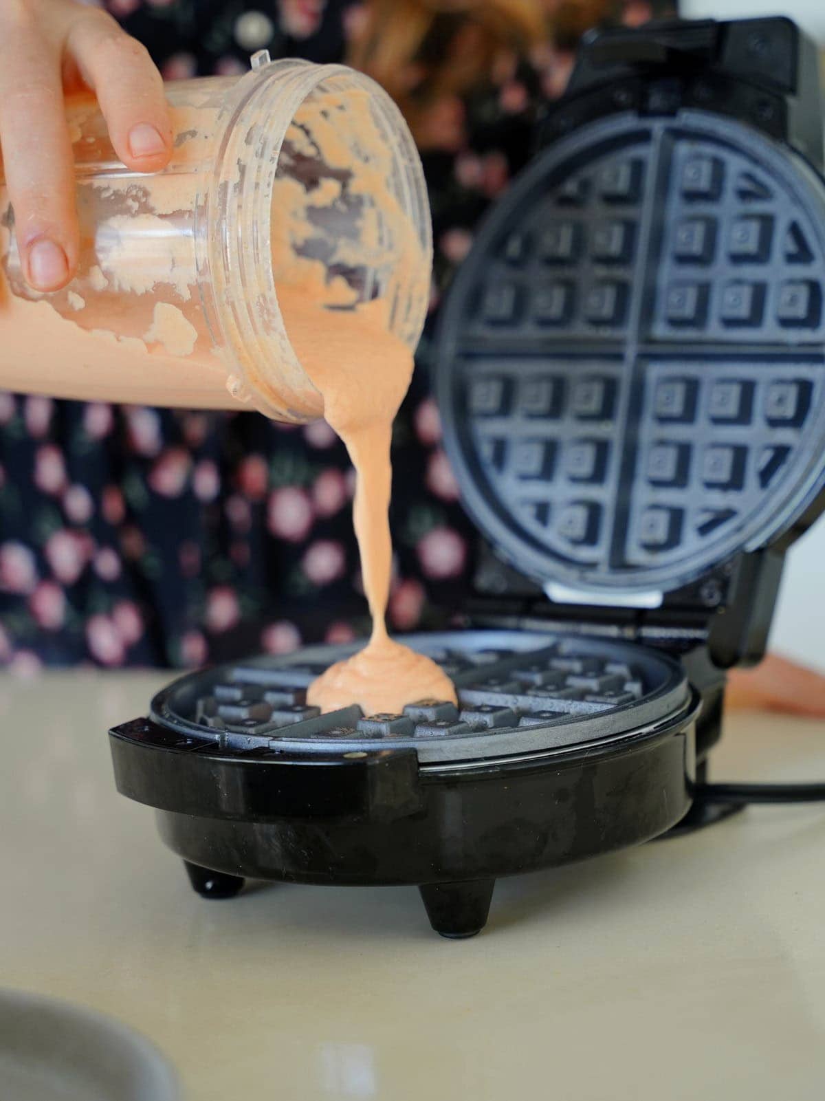 Pouring lentil waffle batter into waffle maker