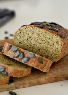 Sliced red lentil bread topped with pumpkin seeds.
