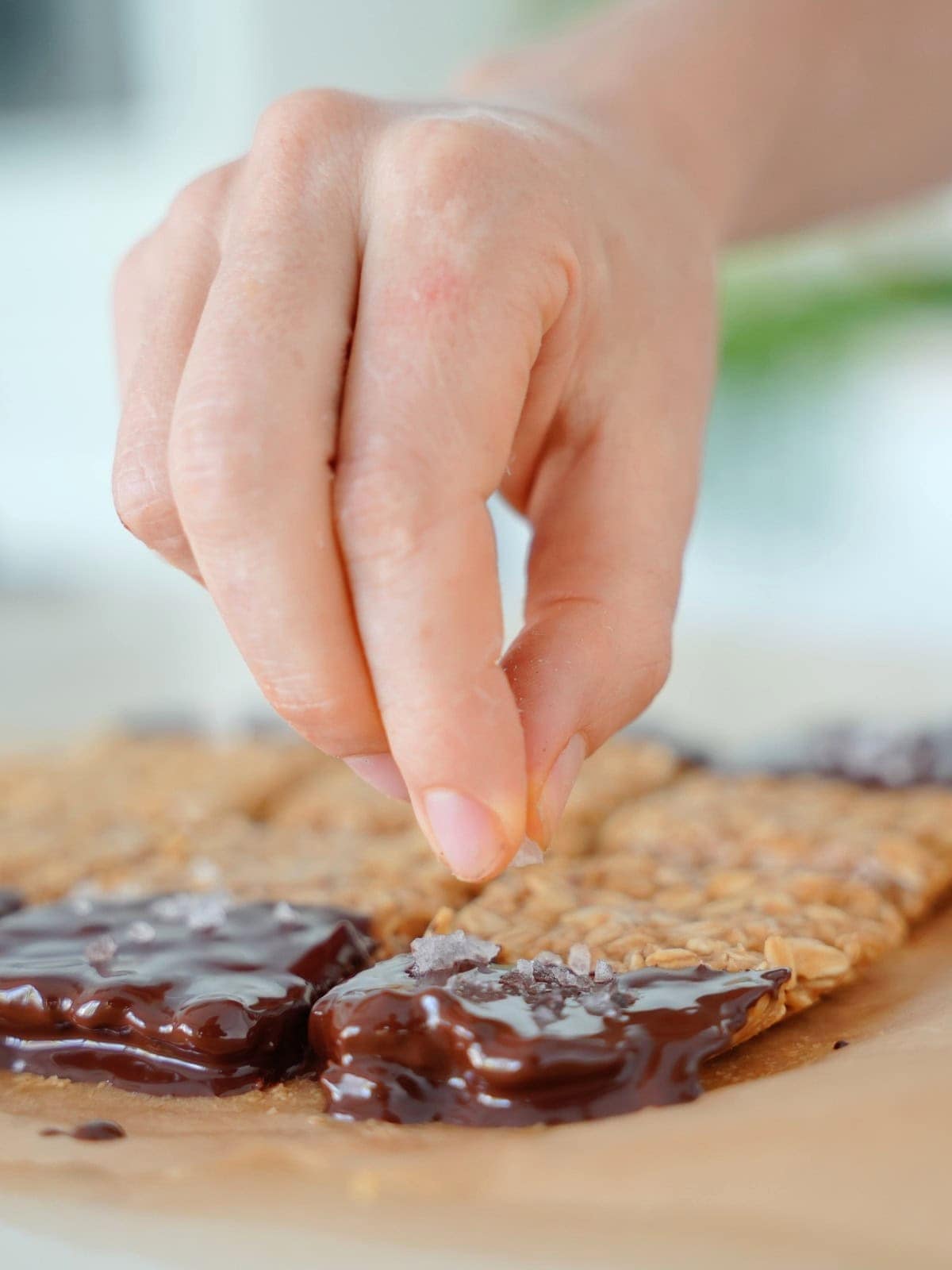 Sprinkling flaky salt over the peanut butter oatmeal bars.