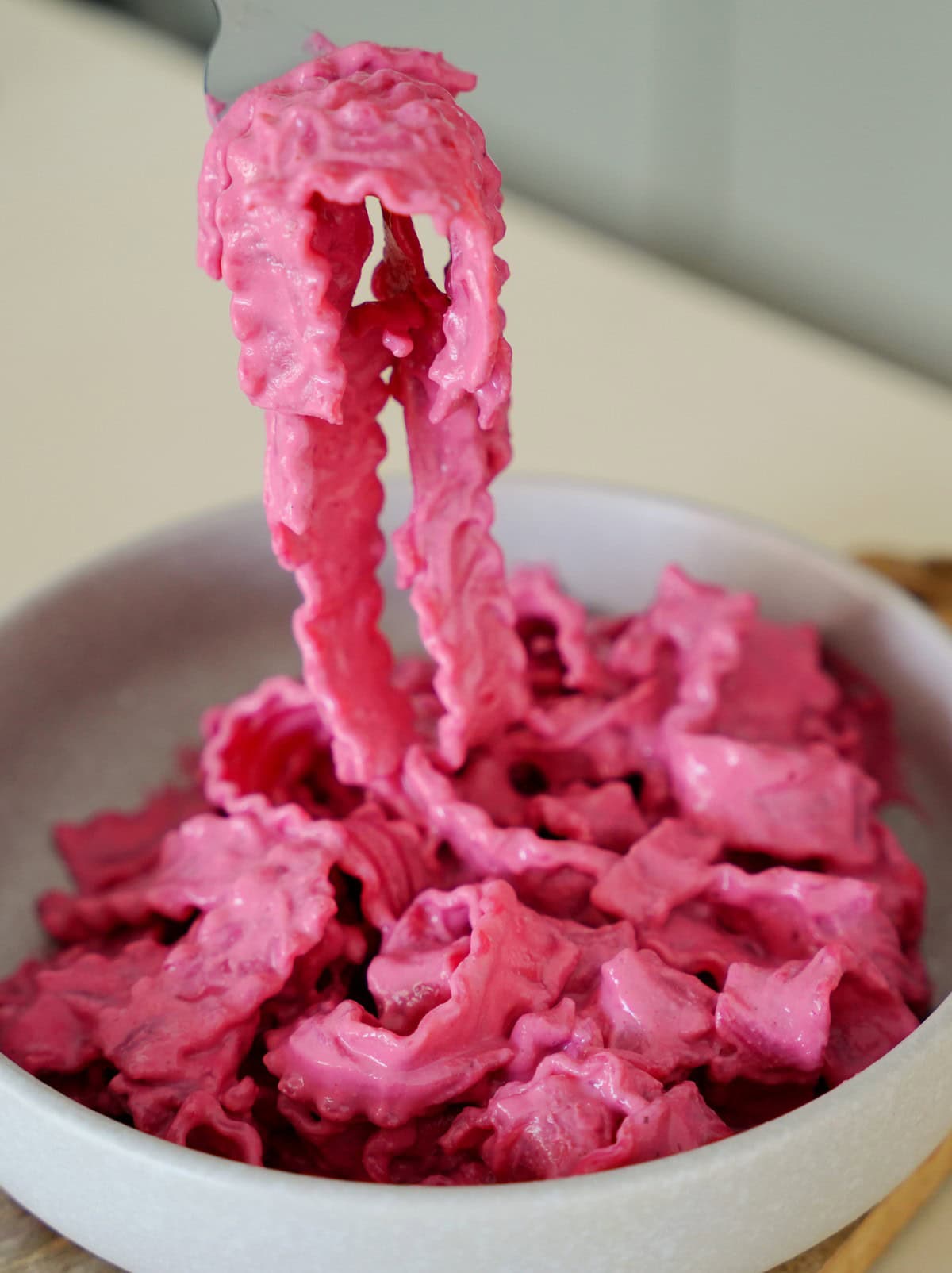 A bowl of Barbie pasta with a fork holding up noodles