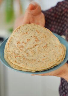 A hand holding a plate with chia oat wraps