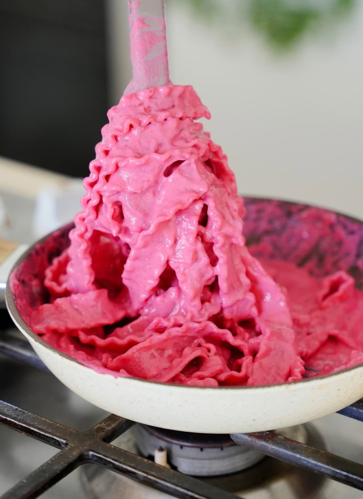Mafaldine noodles tossed in bright pink beetroot pasta sauce