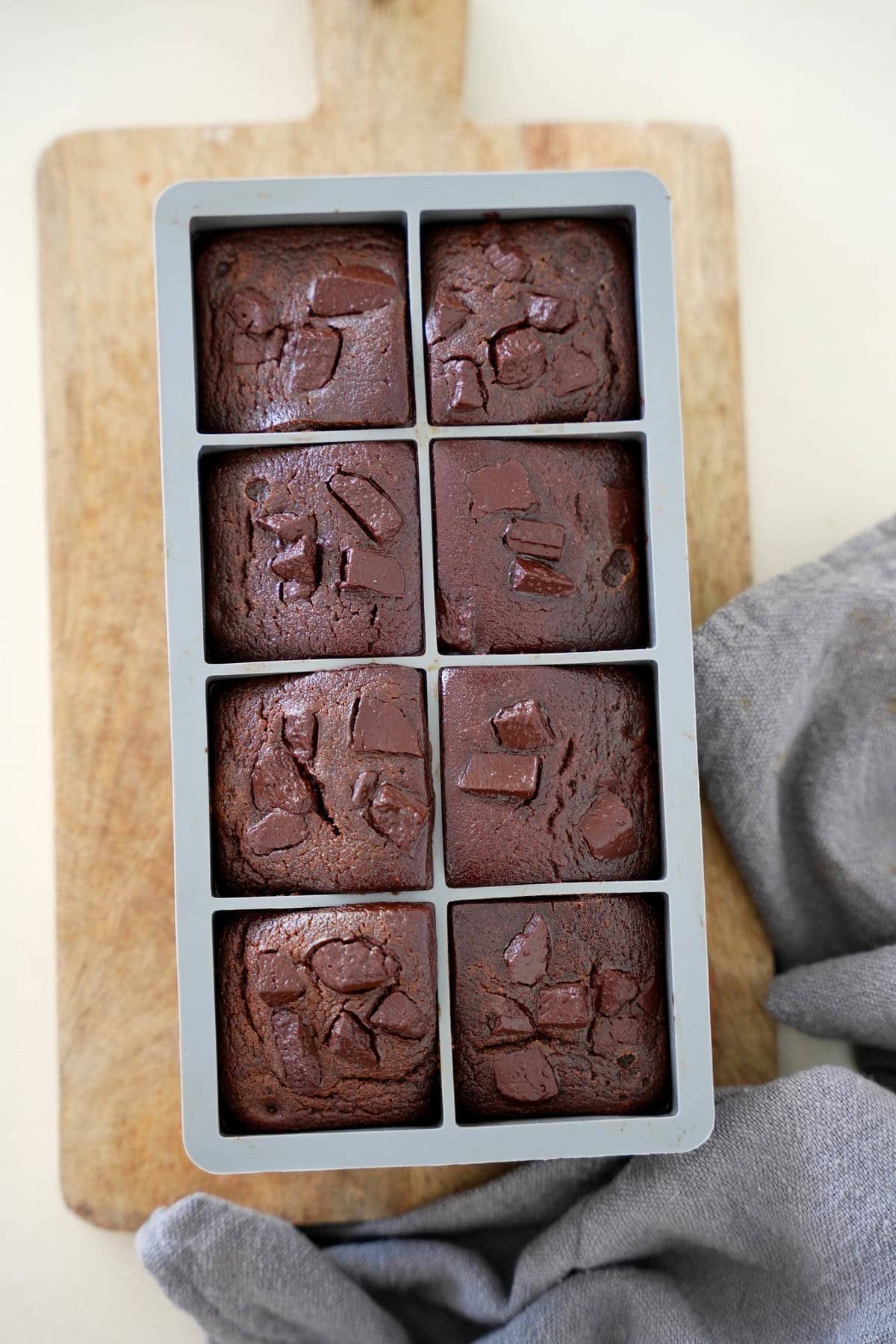 6 red lentil brownies in silicone mold on a wooden board