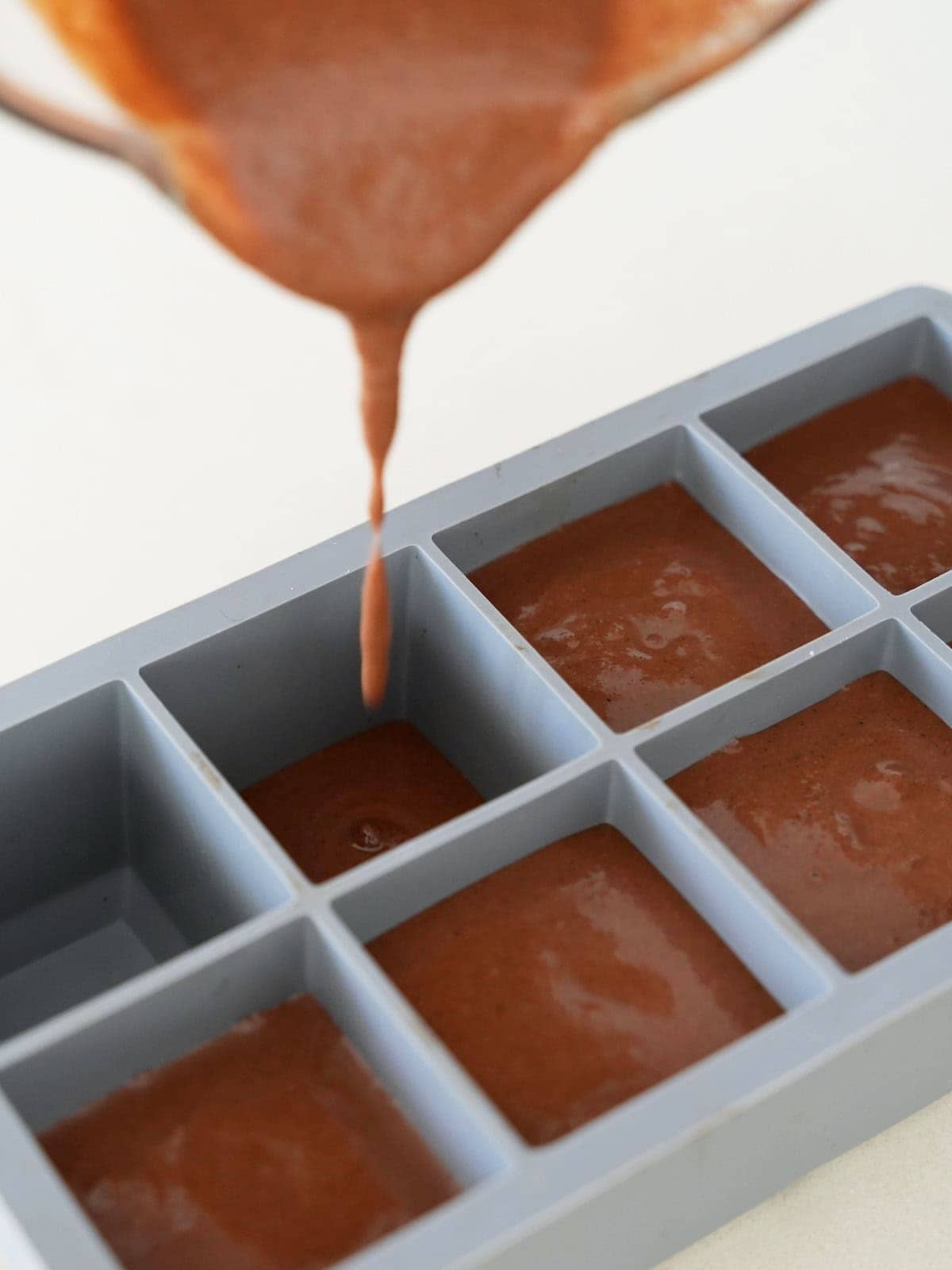 Filling chocolate batter into brownie silicone mold