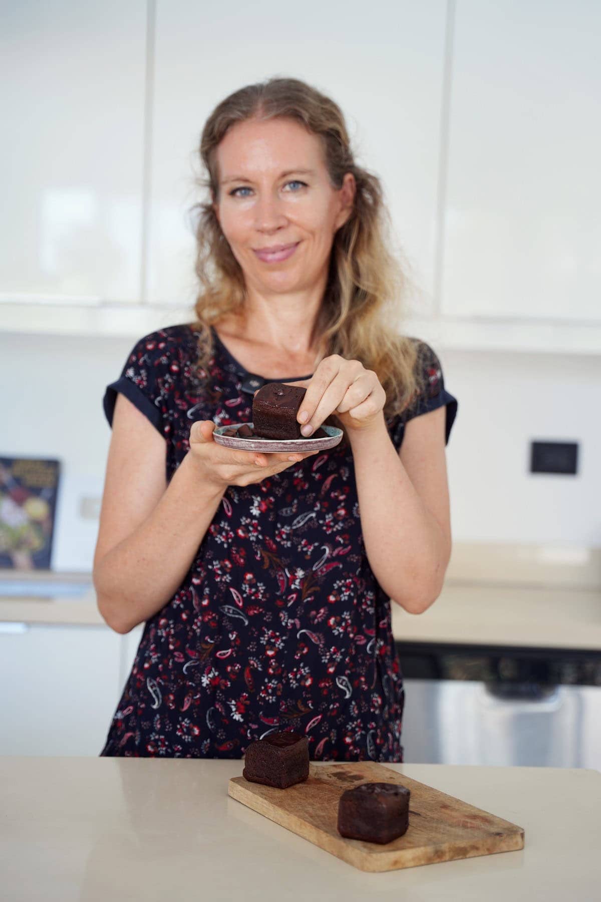 Michaela Vais in bright kitchen with chocolate dessert