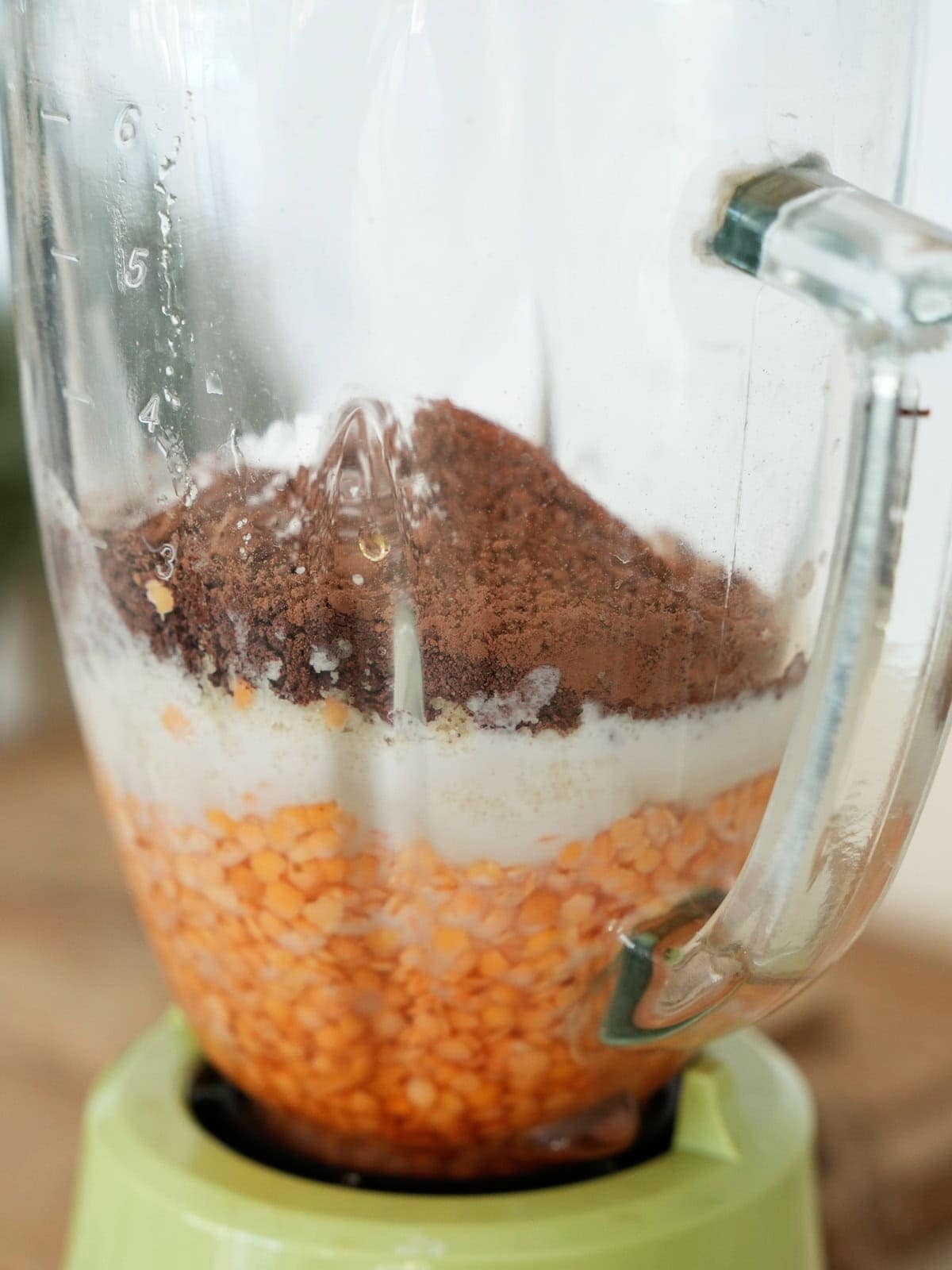 Red lentils, milk and cocoa powder in glass blender jug