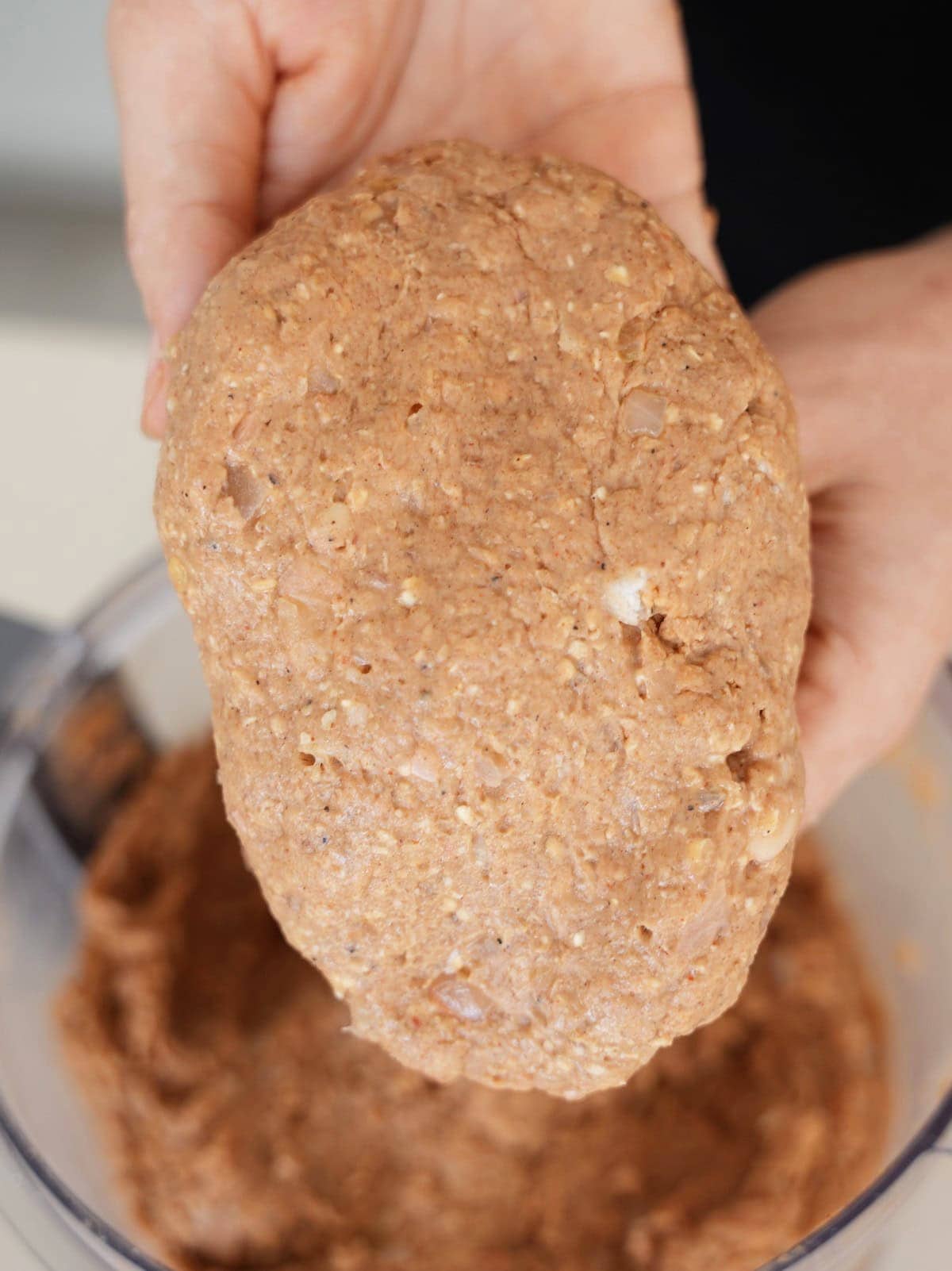 holding up shaped raw vegan steak