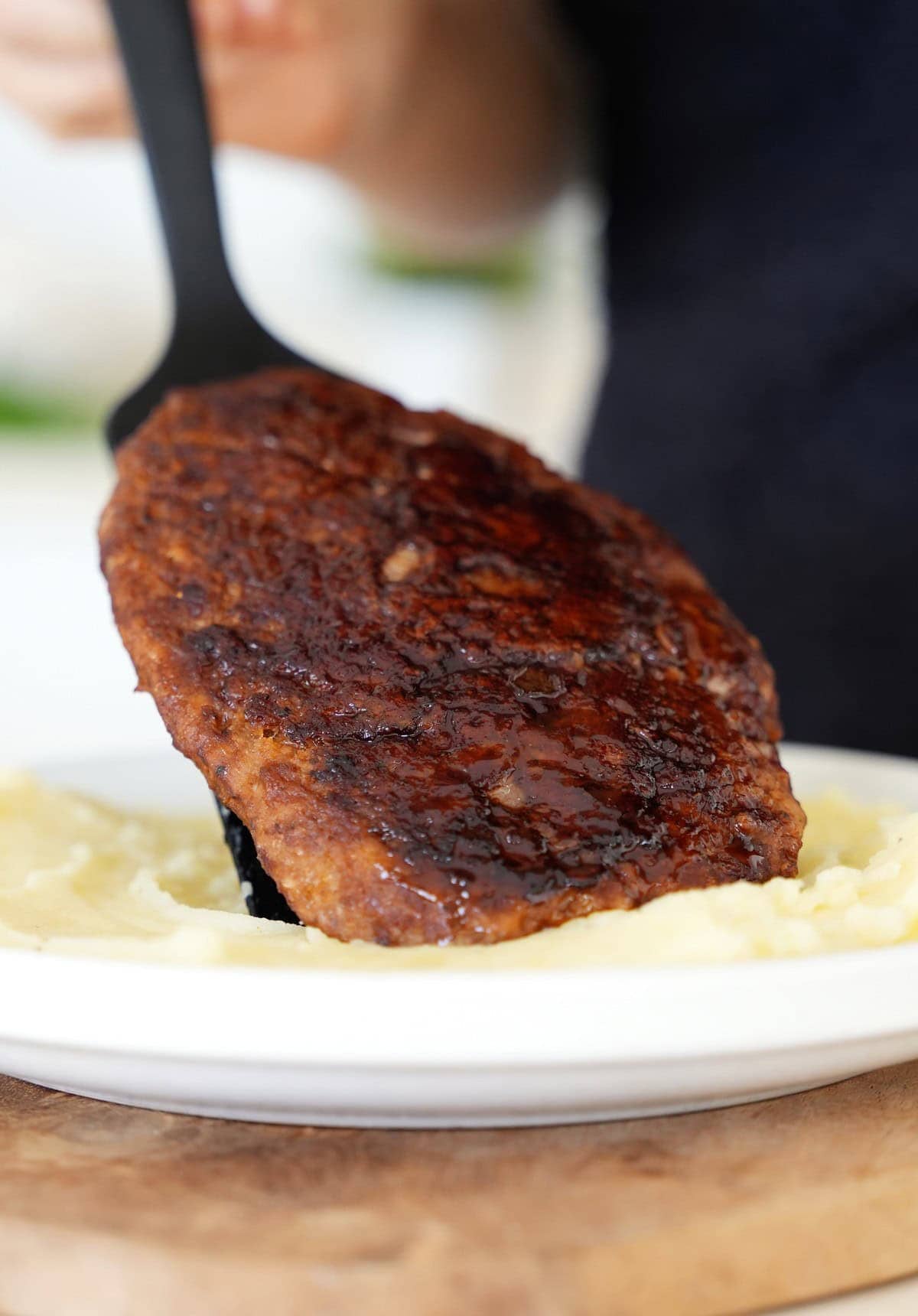 placing a homemade vegan steak on mashed potatoes