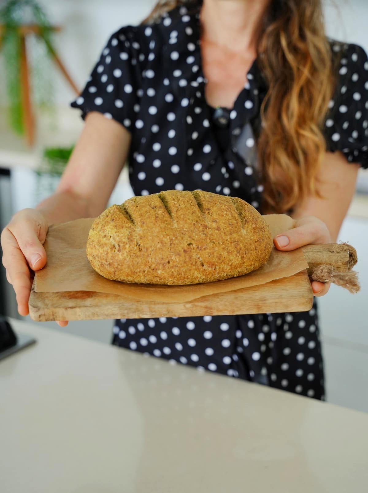 Michaela Vais holding baked loaf on wooden board