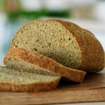 Sliced green pea bread on wooden board
