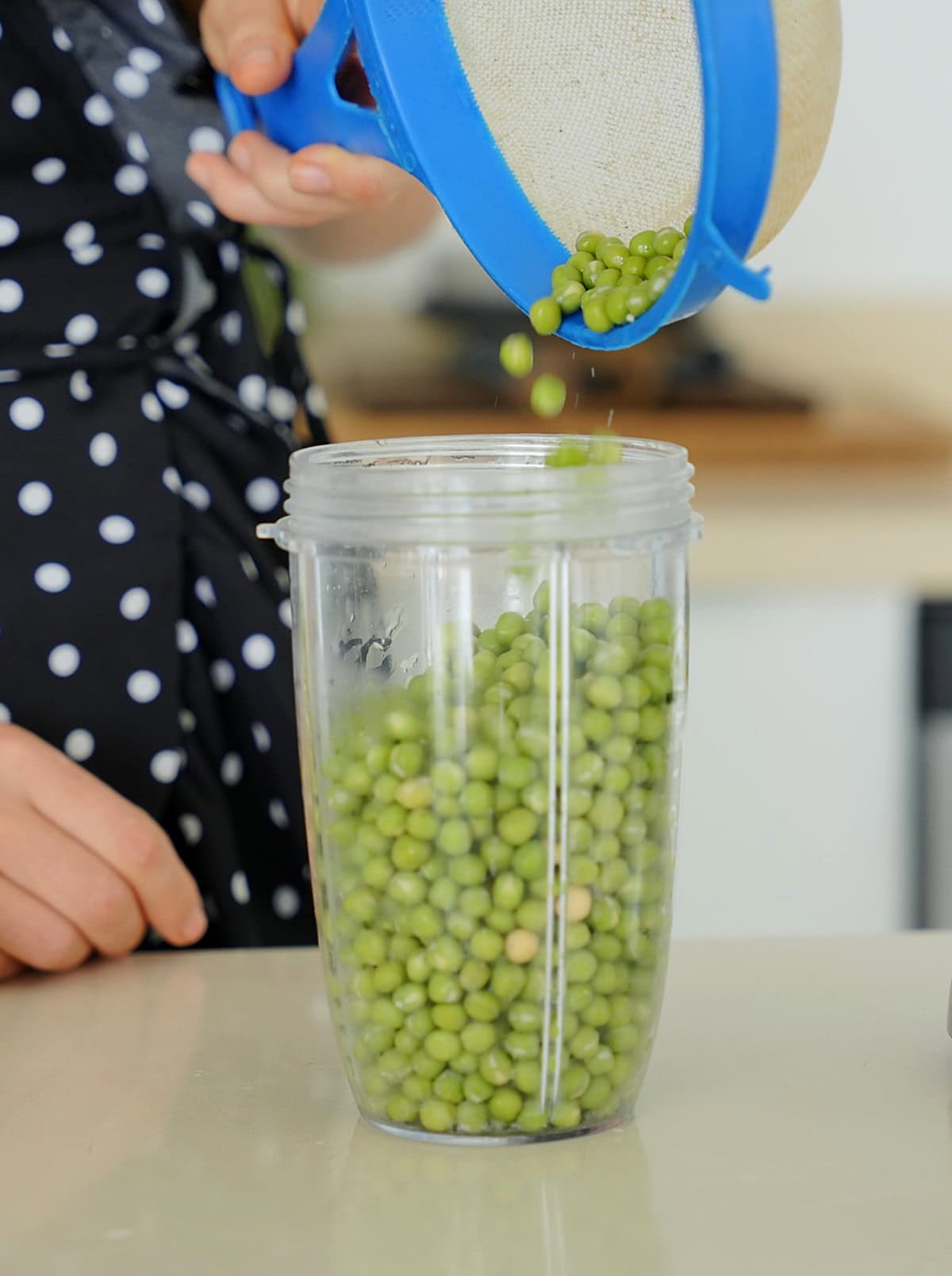 adding soaked peas into blending container
