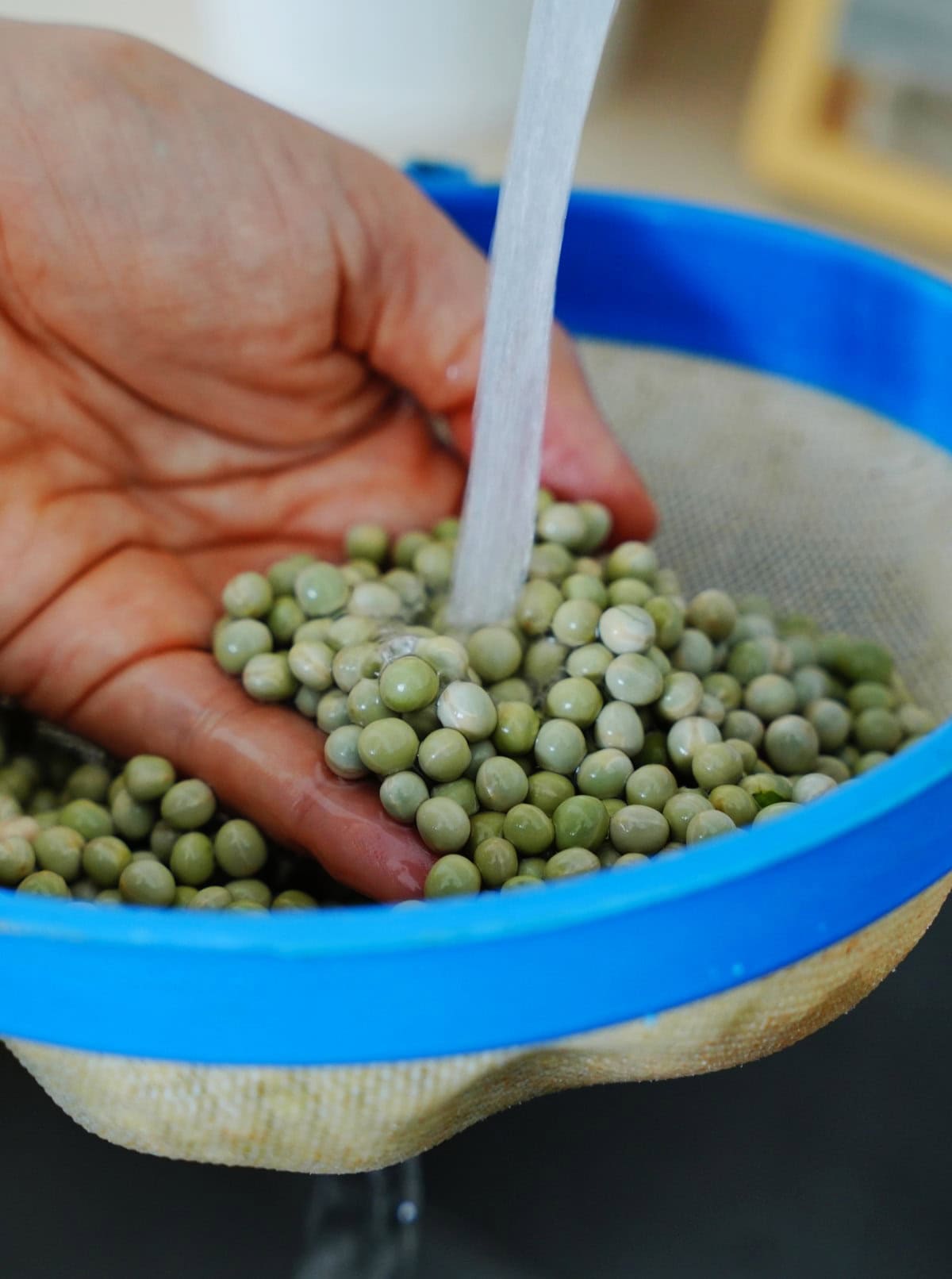 rinsing dried peas in sieve