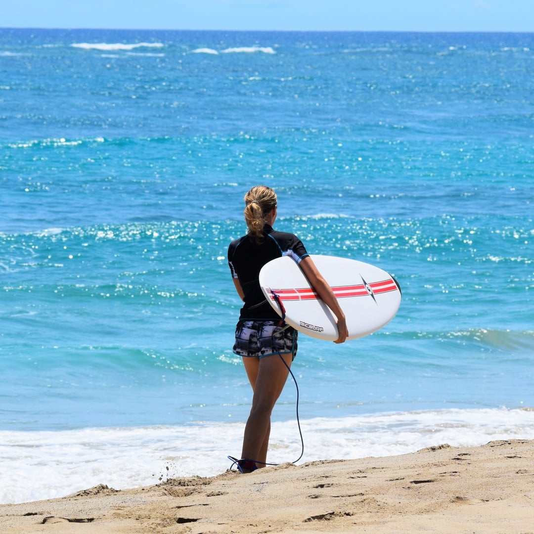 Michaela Vais von Elavegan.com am Strand mit Surfboard